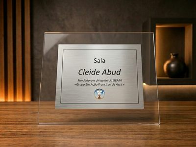 Placa de inauguração em aço inox fixada sobre vidro transparente